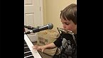 Niño tocando piano, armónica y cantando